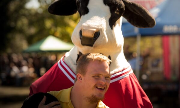 Man with a person in a cow costume
